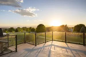 Deck overlooking a field with the sunset.